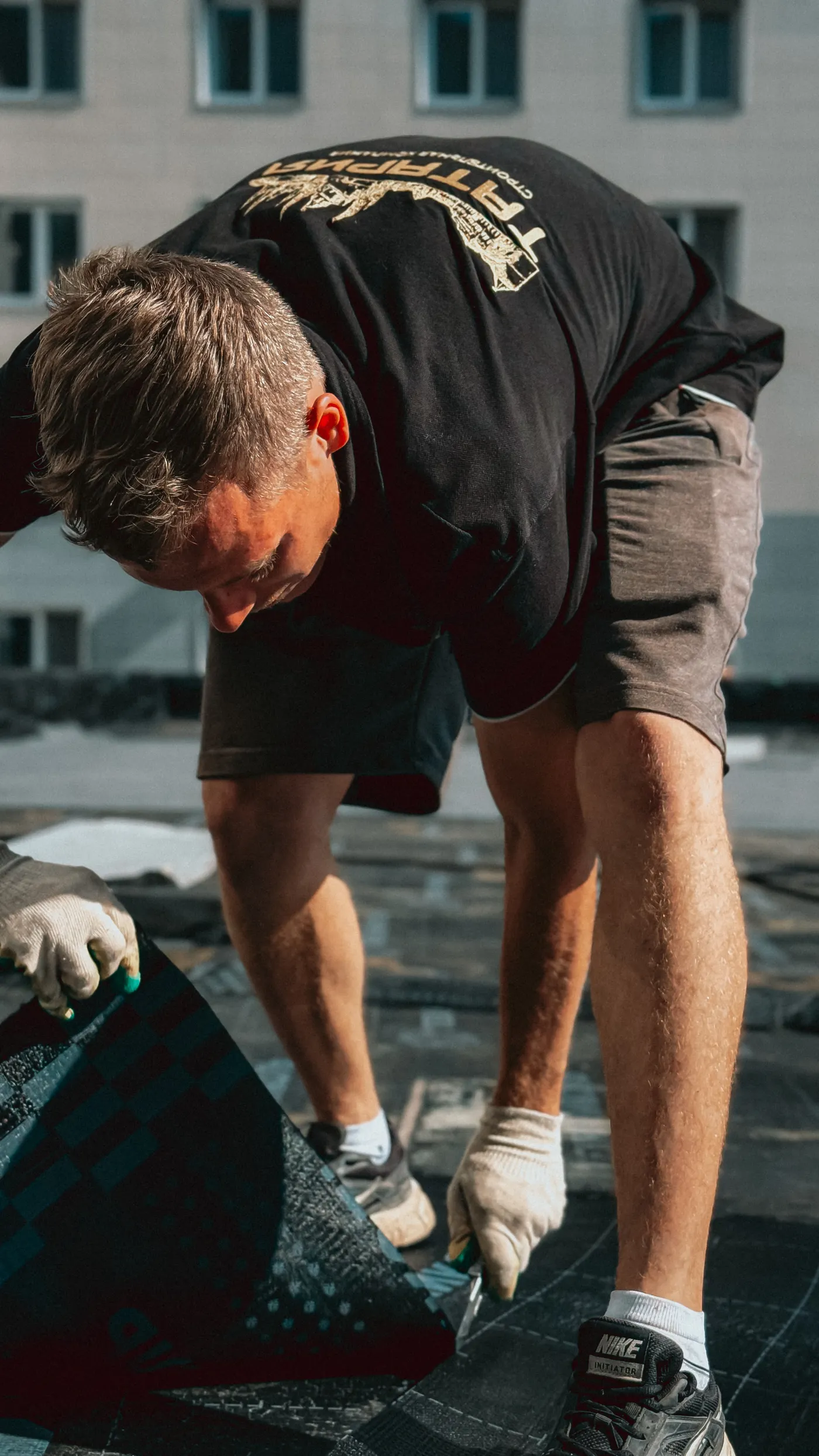 Roofer applying asphalt shingles on a residential roof